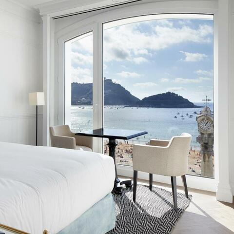 A white bedroom looking out over beach