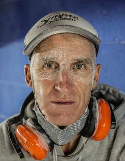 Michael di Sciascio stares into the camera, covered in dust from his boardmaking job in Torquay