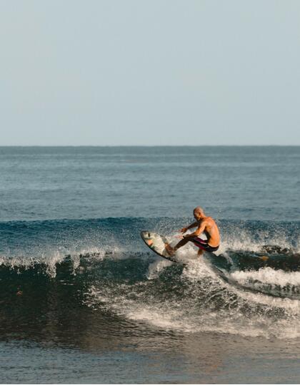 A man on a surfboard rides a wave in Puerto Rico