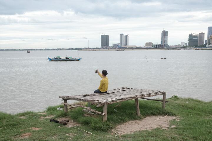 A woman takes a selfie in front of the Mekong river. 