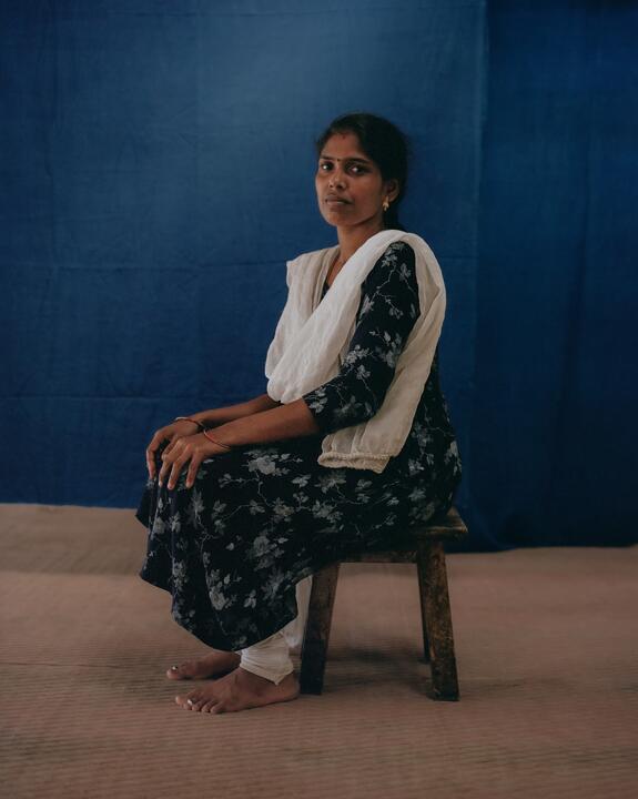 A member of staff seated on a stall at The Colours of Nature, Tamil Nadu, India