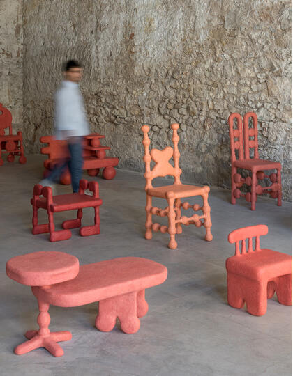 Coral-coloured chairs installation at a gallery