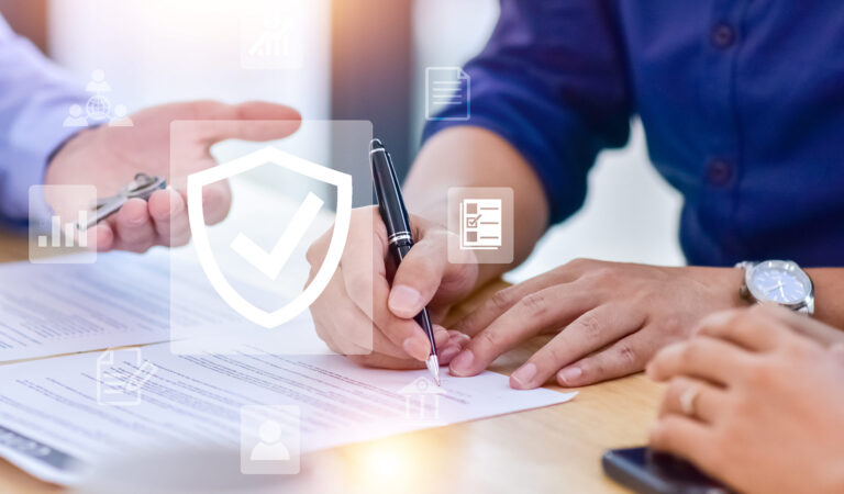 A person signing a home insurance document to safeguard their home from natural disasters.