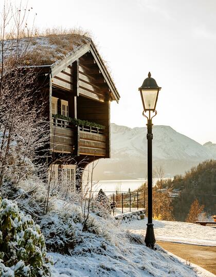 A traditional lamplight beside a snowy cabin 