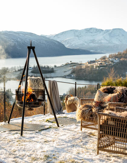 A fire pit and seating area with a snowy mountain view