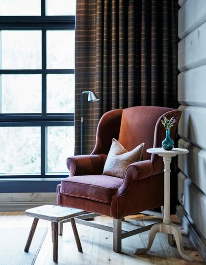 A red armchair in a cabin corner