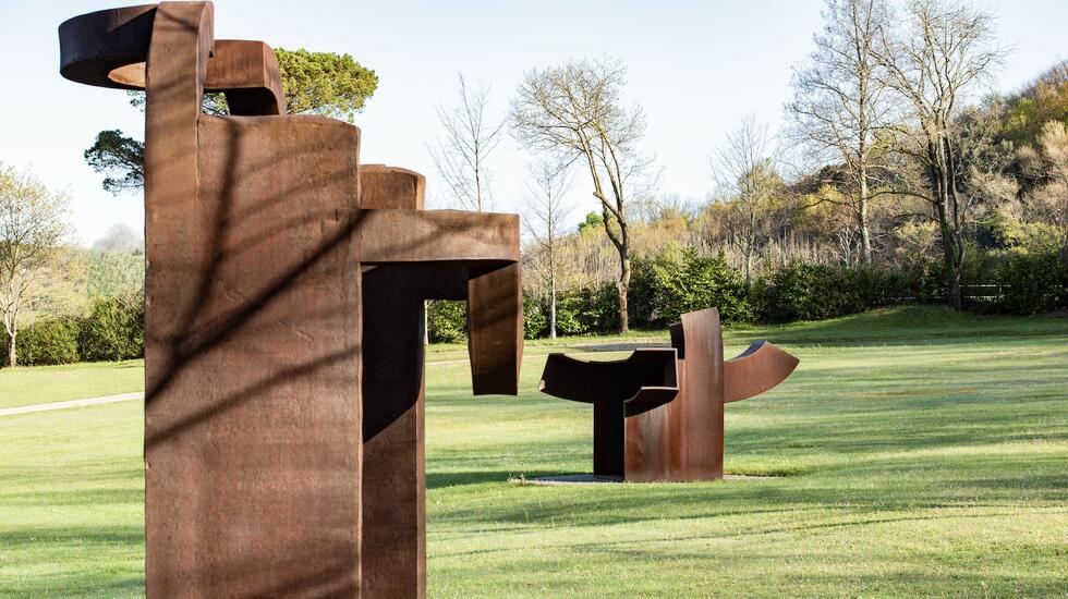 Rusted metal sculptures in a green space