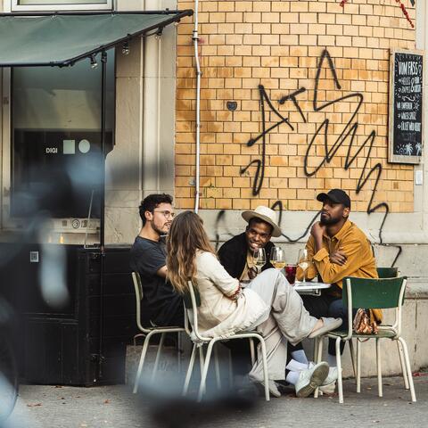 Three people sat outside a bar